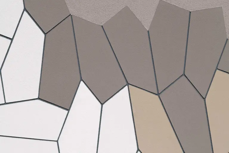 Detailansicht einer Fassade mit vorgefertigten Putzelementen von Sto in Weiß, Beige und Graubraun